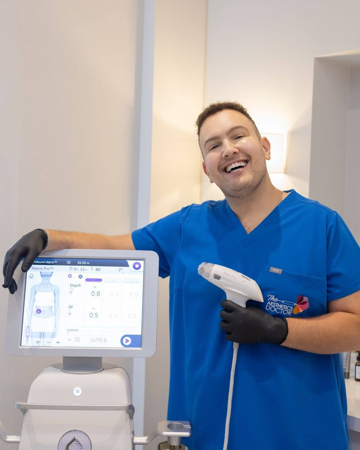 Dr Ahmed stood holding the new matrix pro RF machine 